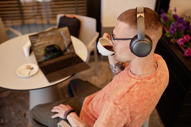 A person in a busy co-working space wearing the Sony WH-1000XM5 headphones. They are typing on a laptop, seemingly undisturbed by the surrounding activity. The focus is on the headphones and the person's concentrated expression, showcasing the headphones' ability to provide a focused workspace.