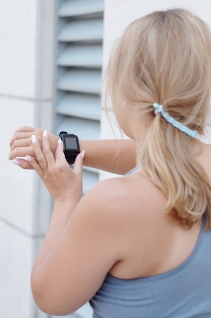 A close-up of the back of a fitness tracker showing the heart rate sensor and skin contact area, highlighting the technology used to measure heart rate and, consequently, calorie expenditure.
