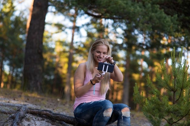 A person holding the AudioMaster X500 portable Bluetooth speaker while hiking in a forest. The speaker is attached to their backpack, and the background shows a scenic view of trees and sunlight. The scene highlights the speaker's portability and suitability for outdoor adventures.