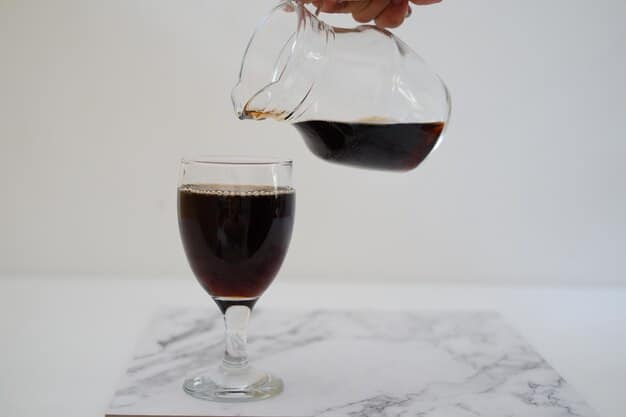 A close-up shot of freshly brewed coffee pouring into a clear glass mug, highlighting the rich color and aroma. The background is slightly blurred, focusing on the coffee's visual appeal and the sense of a perfect brewing moment.