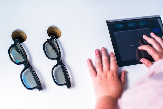 A person's hand holding blue light glasses next to a computer screen displaying lines of code, highlighting the glasses' relevance to digital work.