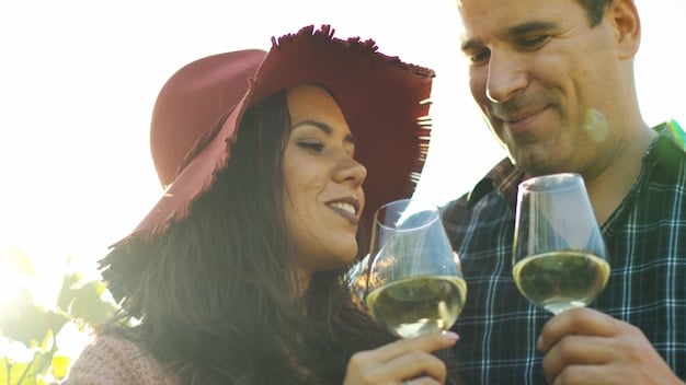 A couple enjoying a wine tasting at a vineyard. They are holding glasses of wine, smiling, with rows of grapevines in the background. The scene conveys a sense of romance and shared pleasure.