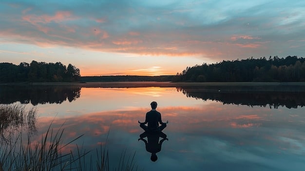 A serene person meditating in a yoga pose by a still lake at sunrise, surrounded by lush greenery, exuding calm and mindfulness.